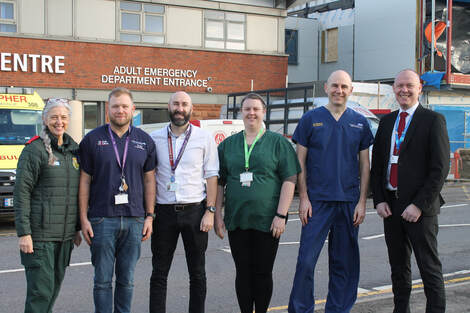 Photo of six people standing in front of the entrance to the James Cook Emergency Department which is under construction.