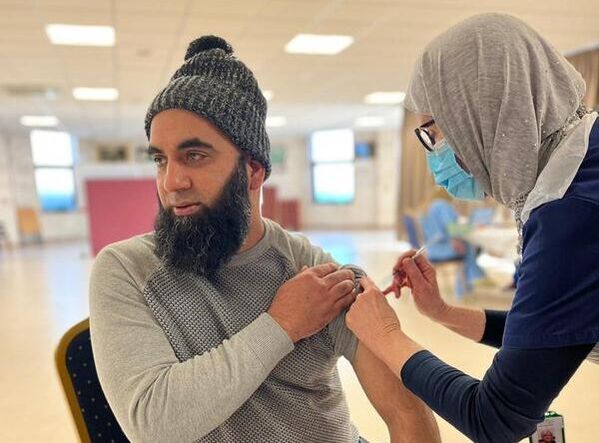 A photo of a man receiving an injection from a nurse.